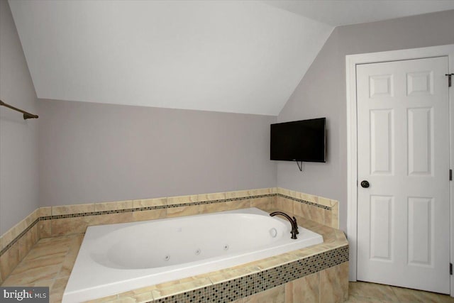 bathroom featuring vaulted ceiling and a relaxing tiled tub