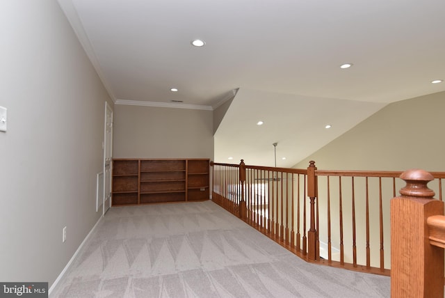 corridor with ornamental molding, lofted ceiling, and light carpet