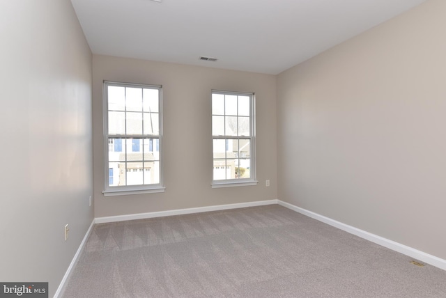 spare room featuring light colored carpet