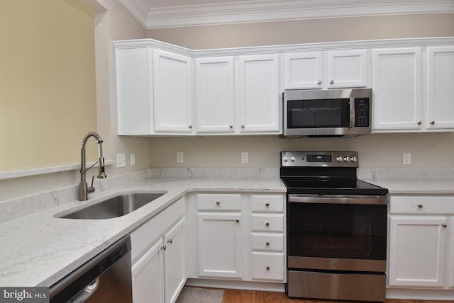 kitchen featuring white cabinetry, appliances with stainless steel finishes, sink, and ornamental molding