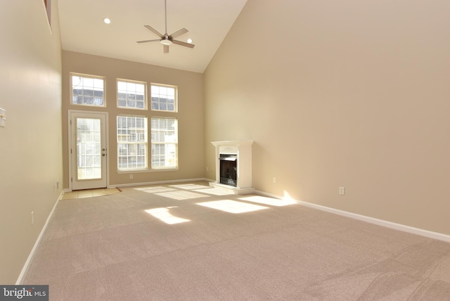 unfurnished living room featuring light carpet, high vaulted ceiling, and ceiling fan