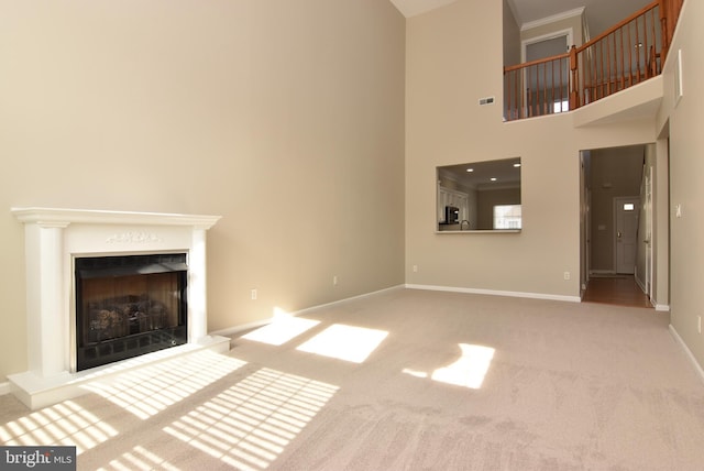 unfurnished living room with a high ceiling and carpet