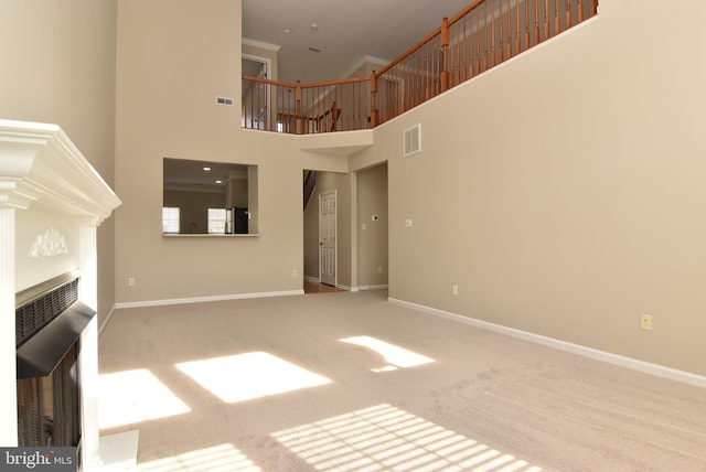 unfurnished living room with a high ceiling and carpet