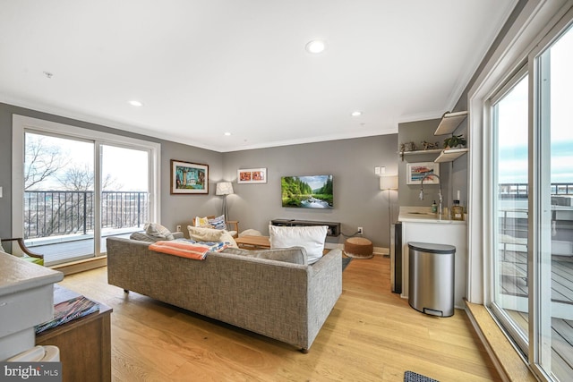 living room featuring recessed lighting, baseboards, light wood-style floors, and crown molding