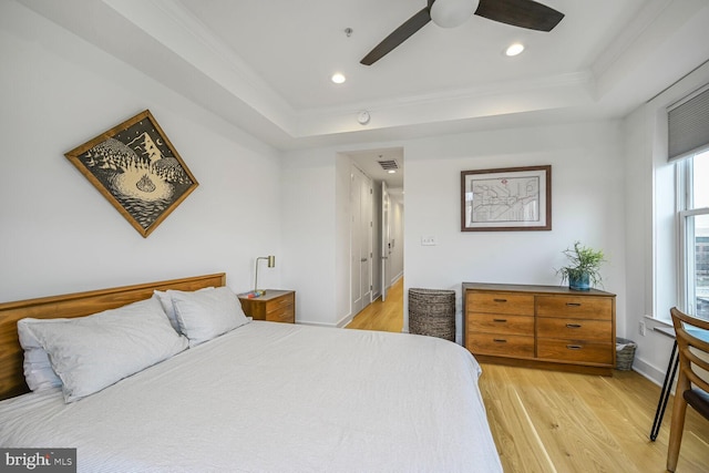 bedroom with recessed lighting, visible vents, a raised ceiling, and light wood finished floors