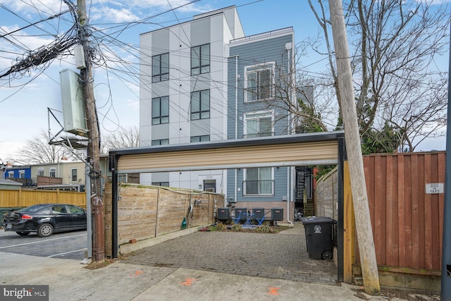 view of front of home featuring fence and uncovered parking