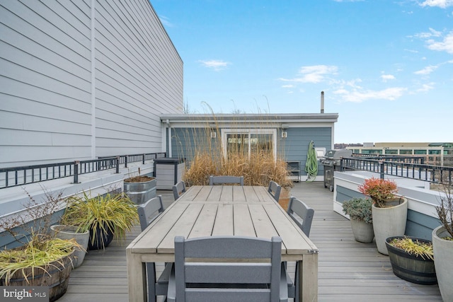 wooden deck with outdoor dining space and area for grilling