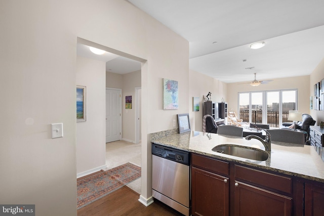 kitchen featuring dishwasher, light stone countertops, sink, and dark brown cabinets