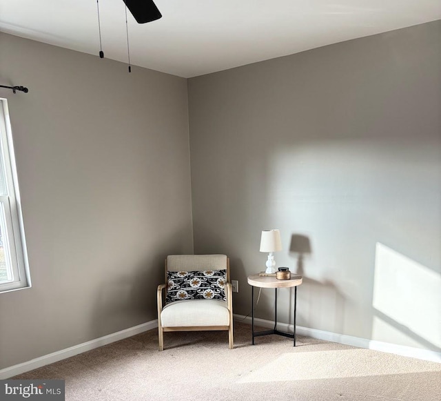 sitting room with ceiling fan and carpet