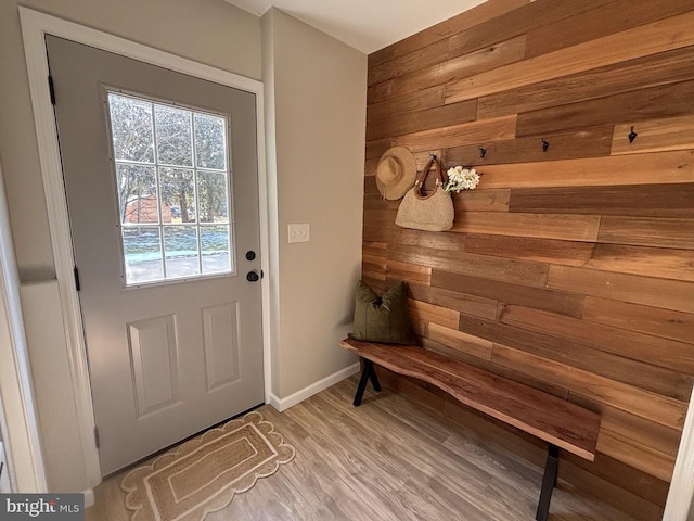 mudroom with hardwood / wood-style flooring and wooden walls