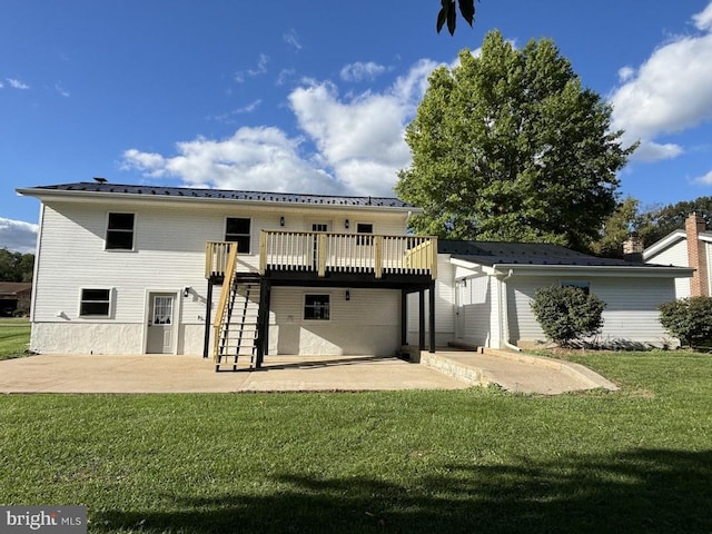 back of house featuring a wooden deck, a lawn, and a patio