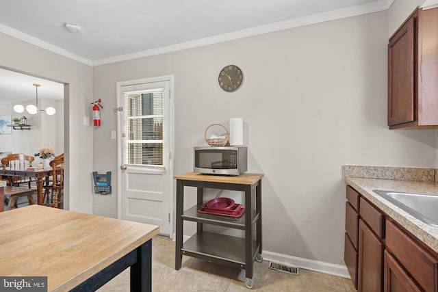 dining room with ornamental molding and sink