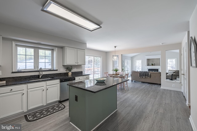 kitchen with sink, white cabinetry, a center island, dishwasher, and pendant lighting