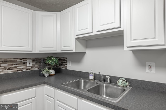 kitchen with sink, decorative backsplash, and white cabinets