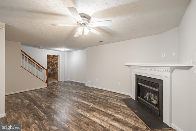 unfurnished living room with ceiling fan, dark hardwood / wood-style flooring, and a textured ceiling