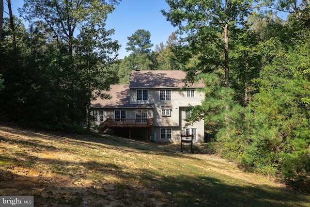 rear view of house featuring a lawn and a deck