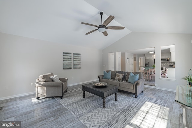 living room with hardwood / wood-style flooring, vaulted ceiling, and ceiling fan