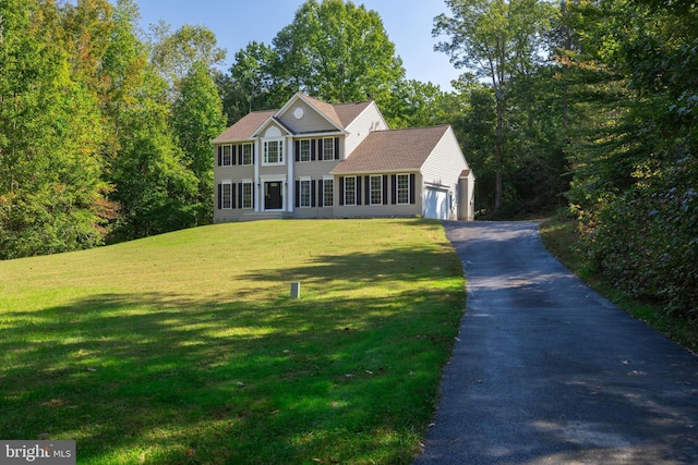 colonial inspired home with a garage and a front yard