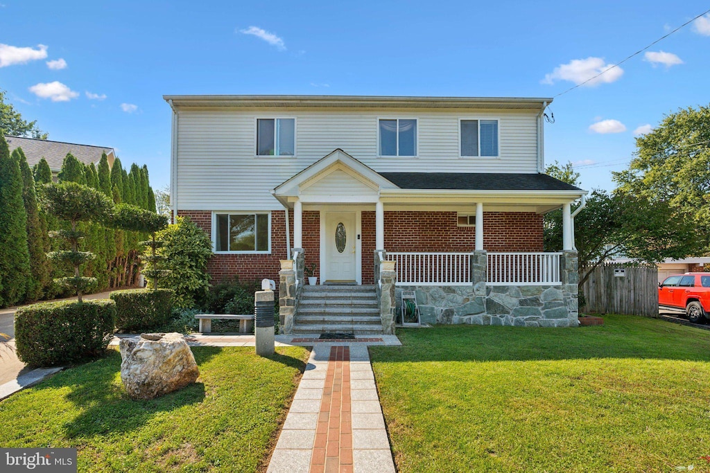 view of front facade with covered porch and a front lawn