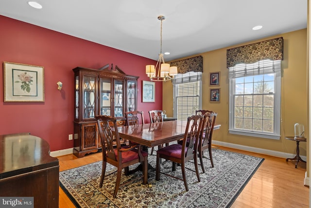 dining space with an inviting chandelier and light wood-type flooring