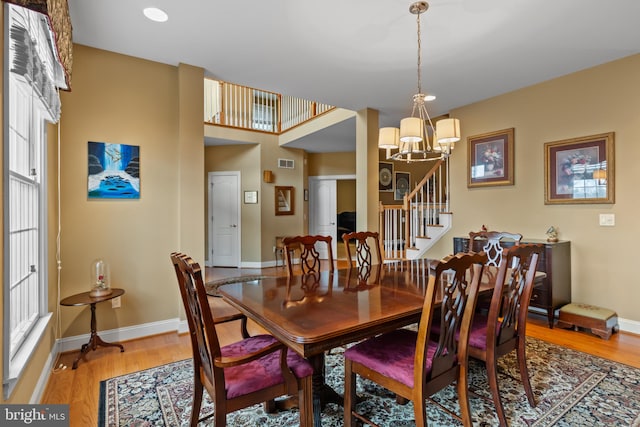 dining space with wood-type flooring and a chandelier