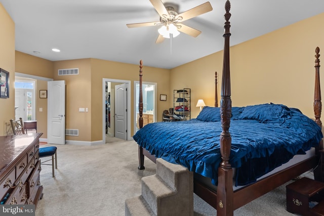 bedroom featuring ceiling fan, light carpet, and ensuite bath