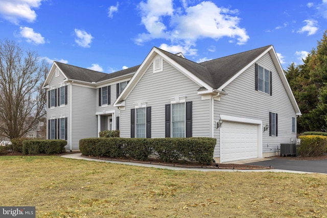 view of front of property with a garage, a front lawn, and central air condition unit