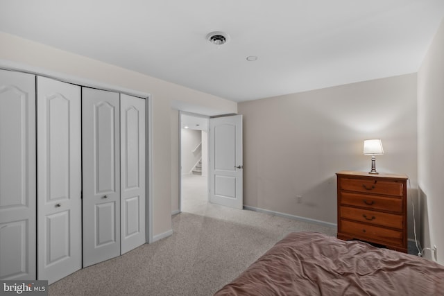 bedroom featuring light colored carpet and a closet