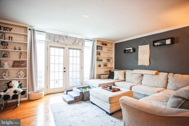 living room with hardwood / wood-style floors, crown molding, and french doors