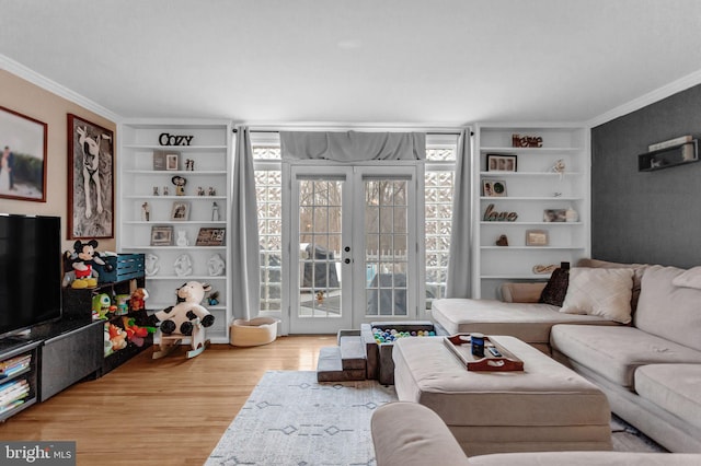 living room featuring ornamental molding, wood-type flooring, built in features, and french doors