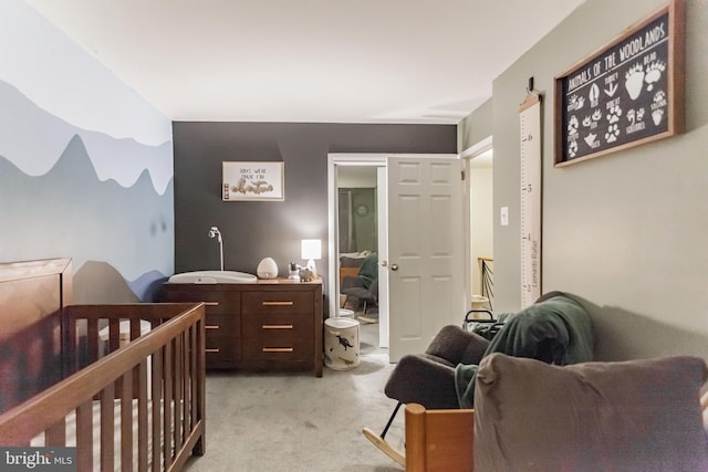 carpeted bedroom featuring a crib