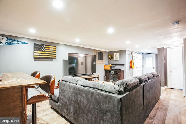 living room featuring crown molding and light hardwood / wood-style floors