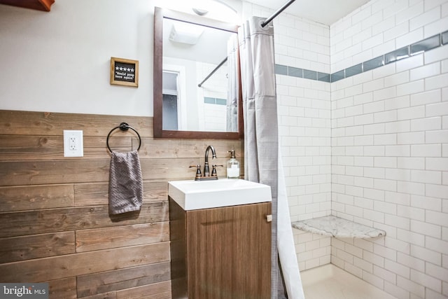 bathroom with a shower with curtain, vanity, and tile walls