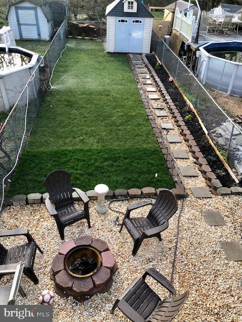 view of yard with a shed and a fire pit