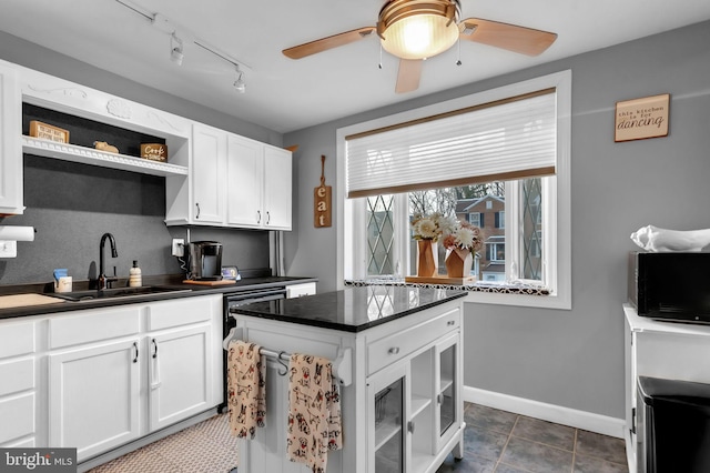 kitchen with sink, white cabinets, dark tile patterned floors, ceiling fan, and track lighting