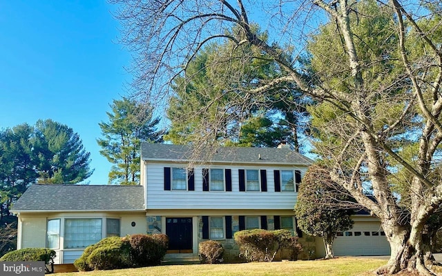 view of front of house with a garage and a front yard