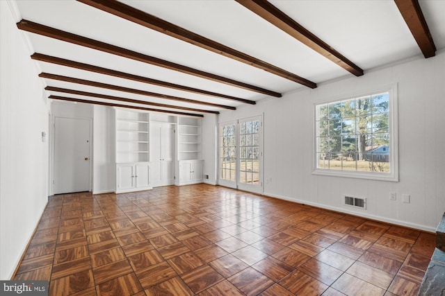 spare room with beam ceiling and dark parquet flooring