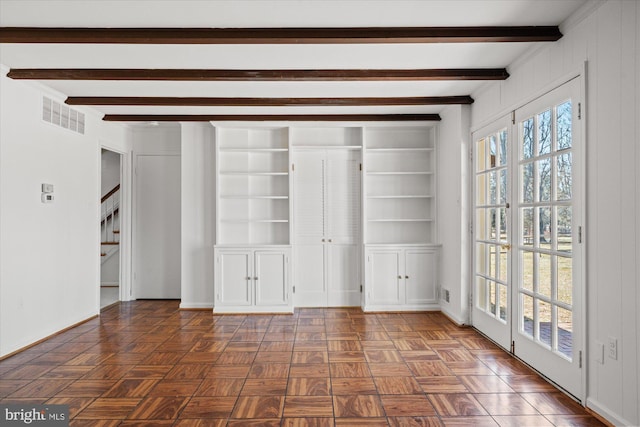 interior space featuring beamed ceiling, built in shelves, and dark parquet floors