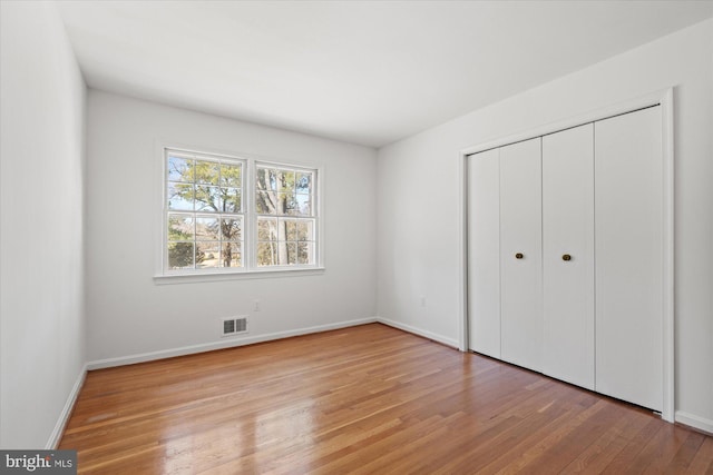 unfurnished bedroom featuring light hardwood / wood-style flooring and a closet