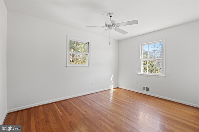 unfurnished room with ceiling fan, hardwood / wood-style floors, and a healthy amount of sunlight