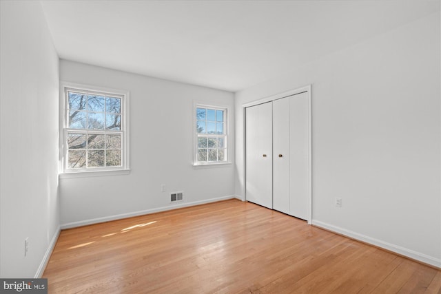 unfurnished bedroom featuring light wood-type flooring and a closet