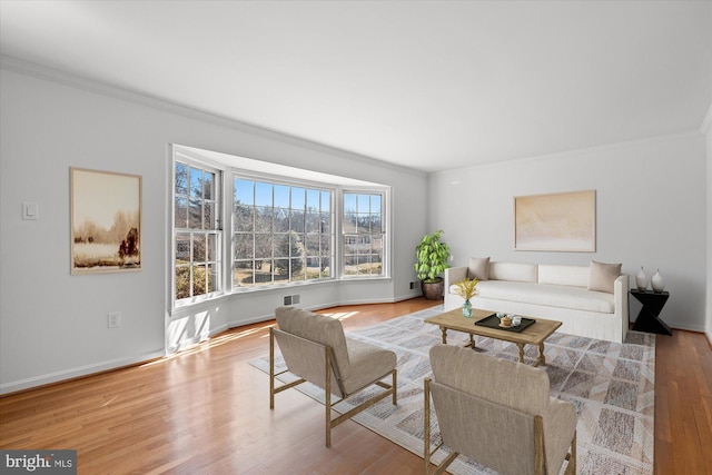 living room featuring ornamental molding and light wood-type flooring