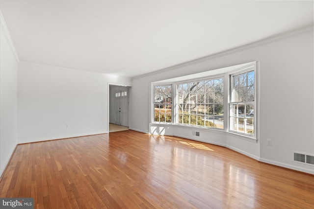 unfurnished living room with light hardwood / wood-style floors and crown molding