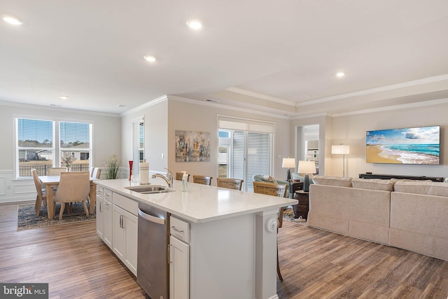 kitchen with sink, light wood-type flooring, stainless steel dishwasher, an island with sink, and white cabinets