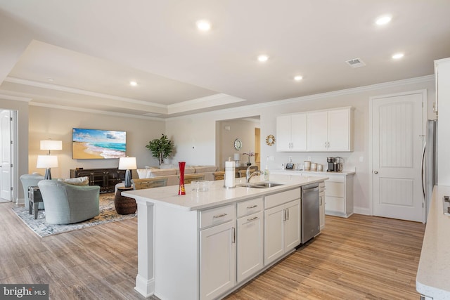 kitchen with an island with sink, dishwasher, sink, white cabinets, and light wood-type flooring