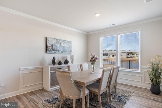 dining space featuring light hardwood / wood-style flooring and ornamental molding