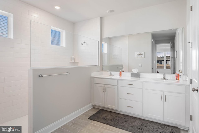 bathroom with vanity and tiled shower