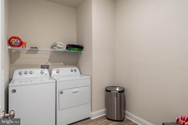 clothes washing area with separate washer and dryer and hardwood / wood-style floors