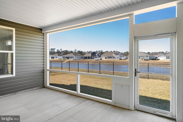 sunroom with a wealth of natural light and a water view