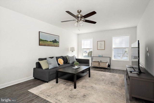 living room featuring dark wood-type flooring and ceiling fan